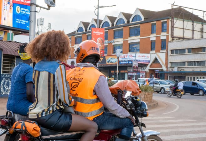An African SafeBoda driver with his female passenger in KAMPALA, UGANDA