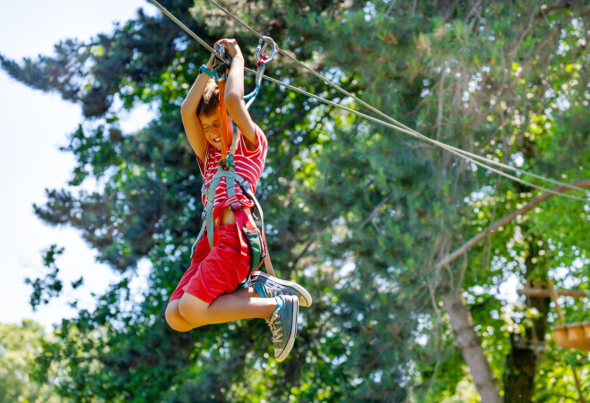 Boy scream and fast slide zip line with trolley